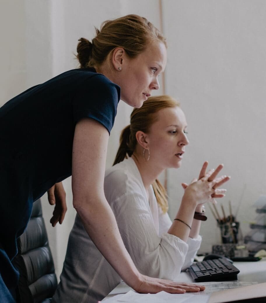 Photo of two women looking at a computer screen